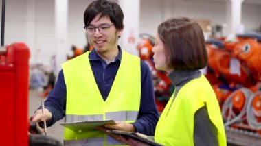 Uzman mühendis acemi çalışana kalite kontrolünün nasıl yapılacağını öğretiyor