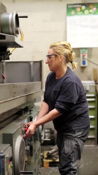 一个女工在工厂的金属机器上工作的垂直录像 — 图库视频影像