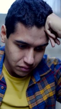 İçerde ders çalışan konsantre Latin bir adamın dikey yavaş çekim videosu.