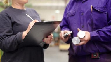 Metal parçalarının kalite kontrolü sırasında iki mühendisin video görüntüleri.