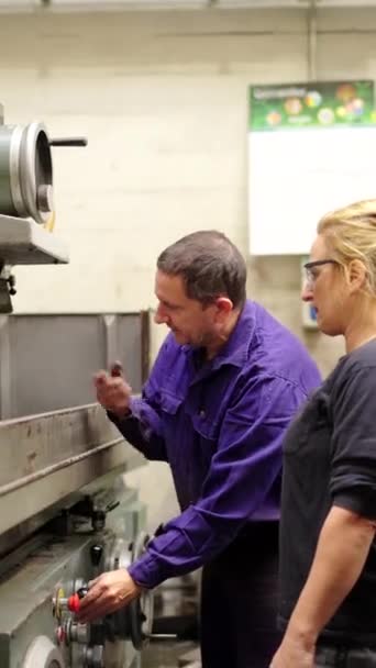 在一名工程师的督导下维修工厂一部重型机械的技师的垂直录像 — 图库视频影像