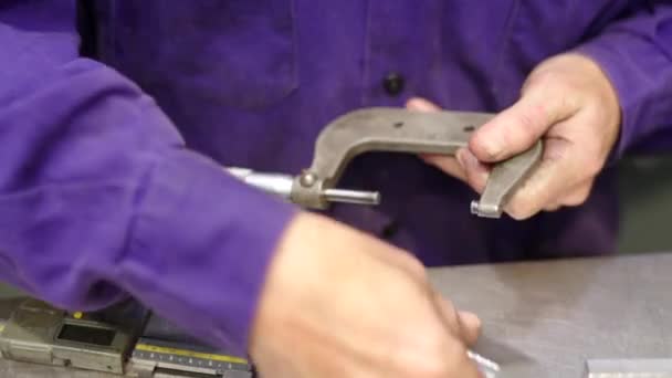 Cnc工場の品質管理で金属片のサイズを測定する男性のクローズアップビデオ — ストック動画