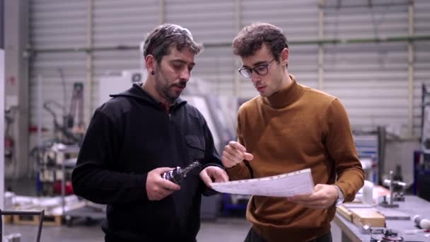 一位工程师与一位在Cnc工厂拿着车床的工人交谈的视频 — 图库视频影像