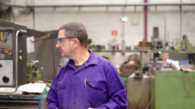 CNC fabrika makinelerinin düzgün çalışmasını kontrol eden bir mühendisin videosu