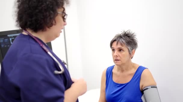 Nagranie Zmartwionej Dojrzałej Kobiety Rozmawiającej Kardiologiem Podczas Pomiaru Ciśnienia Krwi — Wideo stockowe