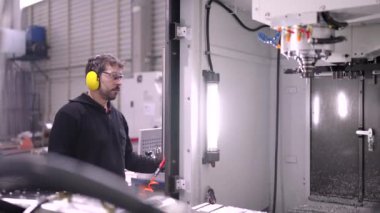 Cnc fabrika hattındaki bir değirmen makinesinin torbasını değiştiren bir işçinin videosu.