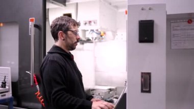 Bilgisayar endüstrisi tarafından kontrol edilen CNC makinelerini inceleyen bir teknisyenin videosu.