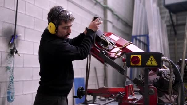 Cnc工場でフライス盤を使用した保護ヘッドフォン付きマニュアルワーカーのビデオ — ストック動画