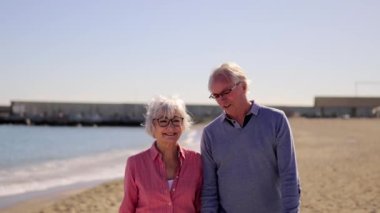 Yaşlı bir çiftin kumsalda güneşlenirken yavaş çekim videosu.
