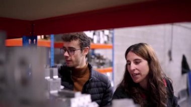 Cnc fabrikasının deposunda materyalleri gözden geçirirken konuşan iki genç mühendisin videosu.
