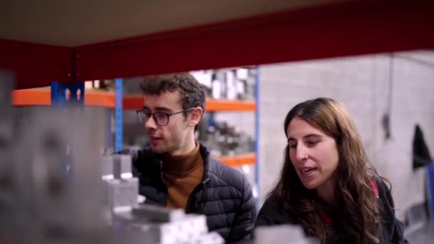 两名年轻工程师在一家Cnc工厂库房修改材料时谈话的视频 — 图库视频影像
