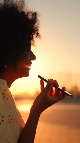 一个非洲女人在日落时坐在城市里用流动扬声器讲话的视频 — 图库视频影像