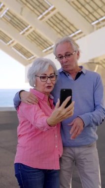 Yaşlı bir çiftin şehir içinde cep telefonuyla konuştuğu yavaş çekim videosu.