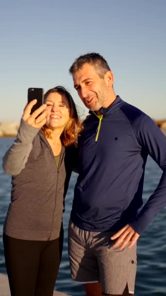 一对成熟的运动型夫妇在海边用手机进行视频通话的慢动作视频 — 图库视频影像
