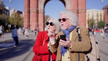 Şehirdeki yol tarifi için cep telefonu kullanan yaşlı bir turist videosu.
