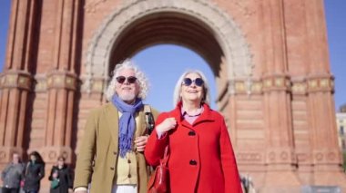 Bir kentin anıtlarını keşfeden modern yaşlı turist çifti videosu.