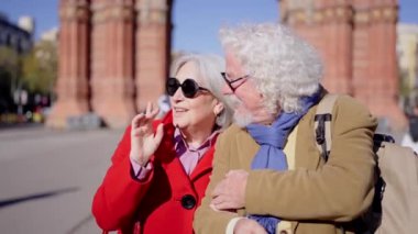 Yaşlı ve mutlu bir turist çiftin şehri gezerken kucaklaşmalarının videosu.