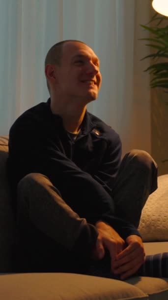 夜にソファーに座っている脳性麻痺の若い男 — ストック動画