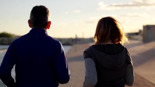 一对老夫妇在海边的城市里一起跑步的背景图 — 图库视频影像