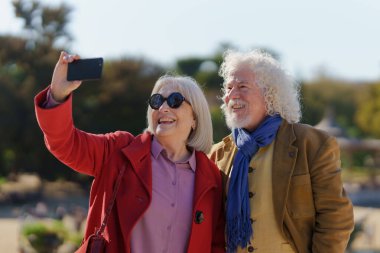 Üst düzey bir çift selfie çekiyor ya da parkta bir video görüşmesi yapıyor.