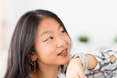 Evde akıllı saat kullanan Çinli bir kadının yakın çekimi.