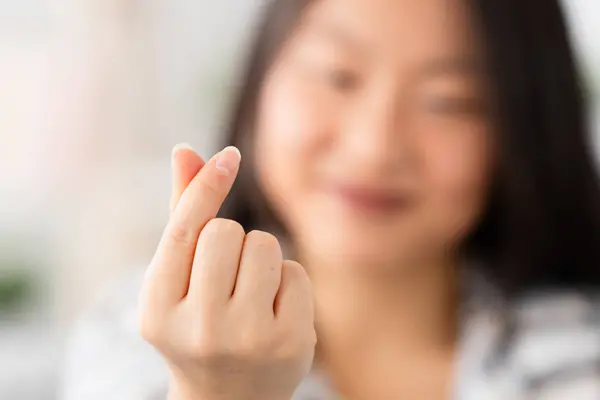 Focus on the hands of a chinese woman gesturing heart shape hand sign