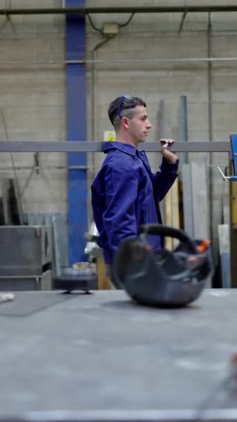 强壮的工人背着一个大夹子走过工厂 — 图库视频影像