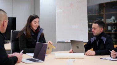 Fabrika genç mühendisleri bir odada toplantı yapıyorlar. İşbirliği ve takım çalışması kavramı.