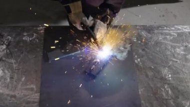 Tanınmayan kişinin yukarıdan görünüşü metal parçaları kaynak yaparak kıvılcım oluşturur