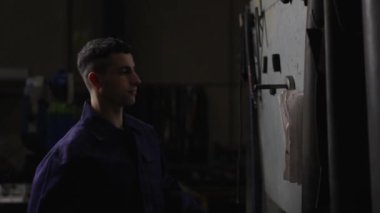 Sinema sahnesi. İşçi görünümlü kağıt bir pano. Fabrika çalışanı karanlıkta belge danışma.