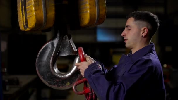 鎖を持ち上げるために大きいクレーンを使用する若い工場労働者 — ストック動画