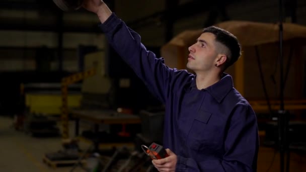 工場で大きなクレーンを使用する若い労働者 — ストック動画