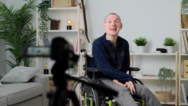 脳性麻痺の若者はカメラに話しかけている 自宅でビデオやライブストリーミングを録画する人 — ストック動画
