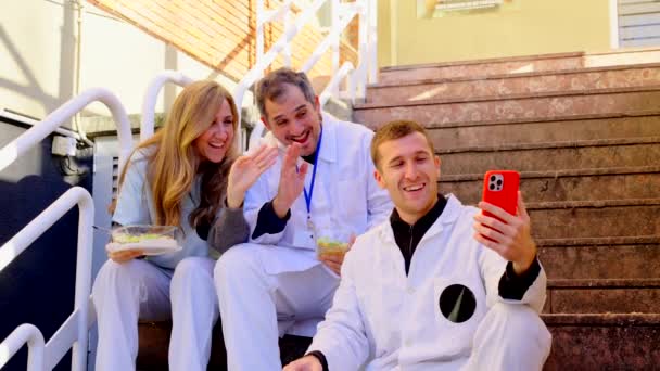 Mała Grupa Pracowników Szpitala Robi Sobie Selfie Siedząc Schodach Przed — Wideo stockowe