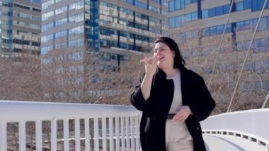 Şehirde yürürken telefonda konuşan kıvrımlı bir kadın..