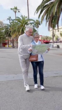 Bir harita ya da plan kullanarak şehri keşfeden kıdemli turist çifti