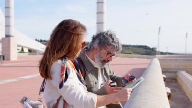 Olgun turist çifti harita ararken güzergah veya istikamet seçiyor.