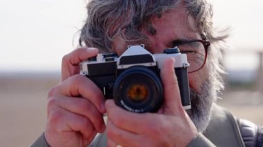 Son sınıf öğrencisi fotoğraf çekiyor. Yetişkin fotoğrafçı kameraya bakıyor..