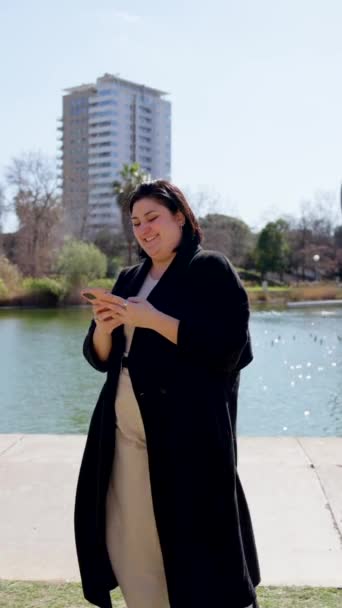 Mulher Curvilínea Usando Telefone Enquanto Caminhava Parque Mensagens Texto Pessoa — Vídeo de Stock