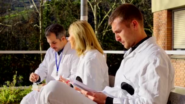 屋外で休憩している医師のグループ 病院の外で休んでいる人たち — ストック動画