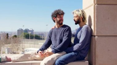 Homoseksüel genç çift konuşuyor. İki adam dışarıda rahatlıyor ve eğleniyor..