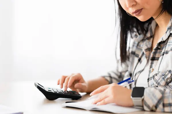 一个中国女人用计算器检查家里的财务时 侧视特写和复制空间 免版税图库照片