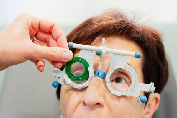 将视力测试玻璃杯放在病人手上 视力和眼科概念 图库图片