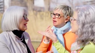 Bir grup kıdemli bayan arkadaş dışarıda konuşuyorlar..