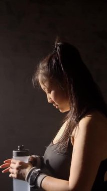 Genç Asyalı sporcu kadın su içiyor. Susuzluk konsepti