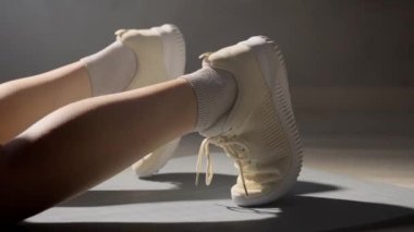 Egzersiz yaparken ayaklarınızı paspasın üzerine koyun. Tanınmayan bir kadın kalas yapıyor..