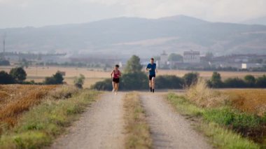 Gün batımında yolda koşan genç bir çift. Arkadaşlar dışarıda çalışıyor..