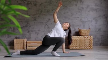 Genç Çinli kadın evde pilates egzersizi yapıyor. Kapalı alanlarda gerinen kişi.