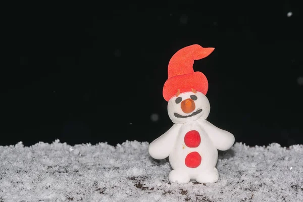 Toy snowman in the snow. Snowman from the snow. Christmas snowman