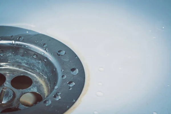 Stock image Draining the water into the sink. Drops of water on a white sink. Take care of hygiene